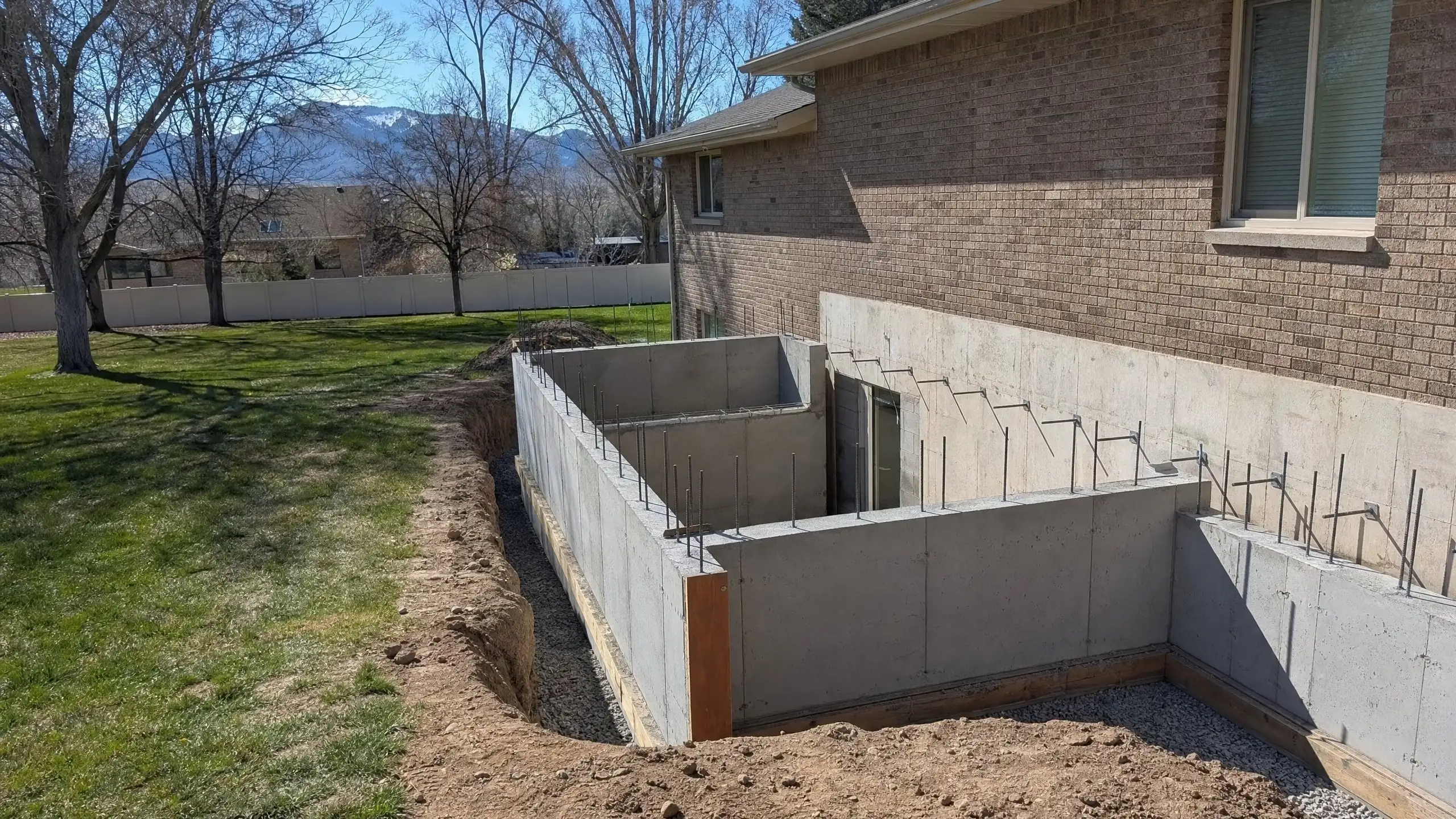 Formed foundation walls with reinforcing steel for an addition beside an existing brick house