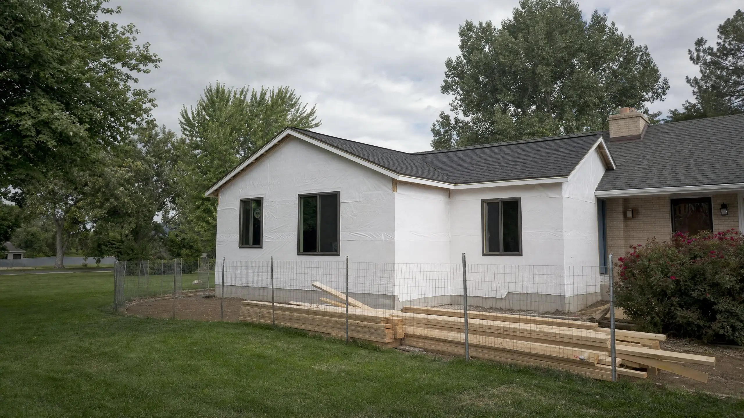 Dried-in home addition with house wrap, windows and roofing, tied into an existing rambler