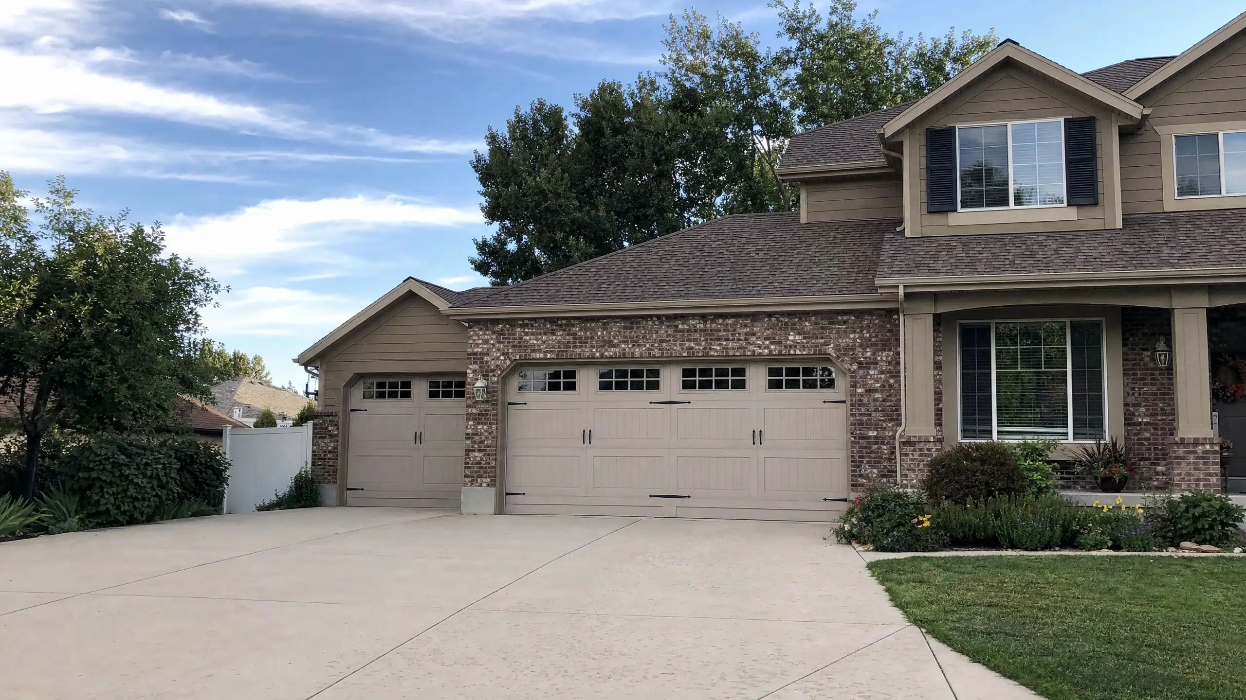 Home with a third garage bay added beside the original garage, stepped back with a matching gable and brick