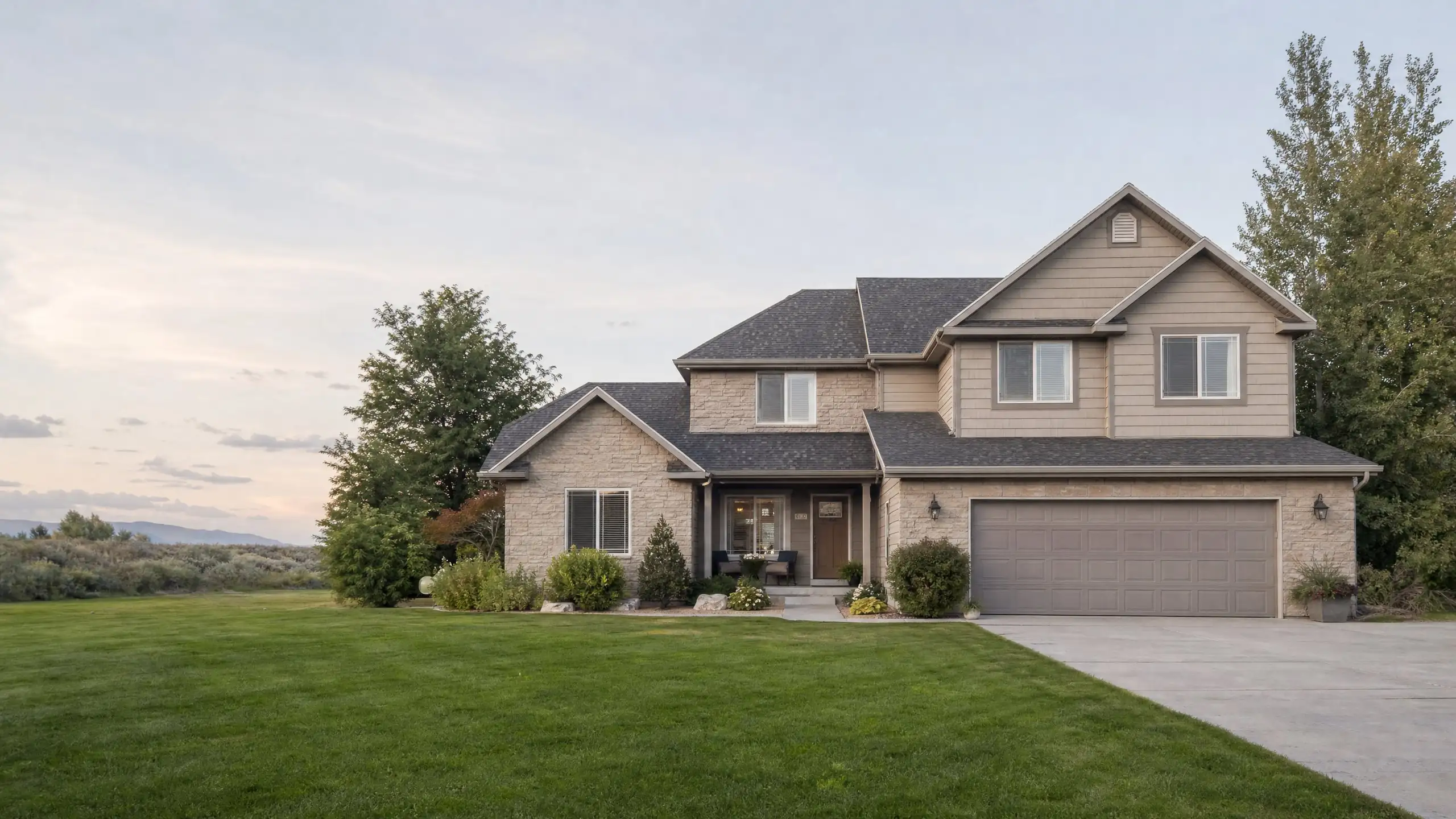 Two-story home on a large lot with an added garage wing and room above in matching siding and stone